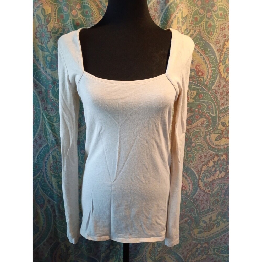 white long-sleeve top featuring a flattering, classic square neckline and a...